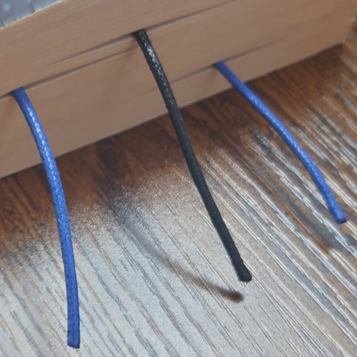 Close-up of a book with blue and black waxed cotton cord on a wooden surface